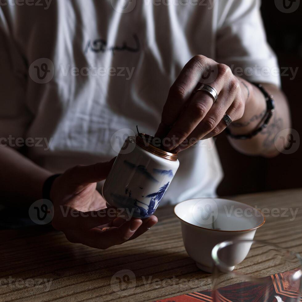 The Art of Tea Preparation Gently Pouring Leaves from a Container for Enjoyment and Calmness photo