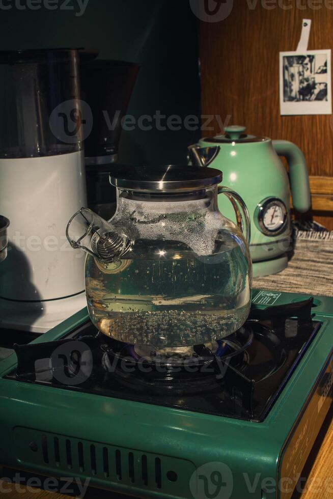 A teapot rests on the stove as boiling water bubbles in a cozy kitchen, creating serenity photo