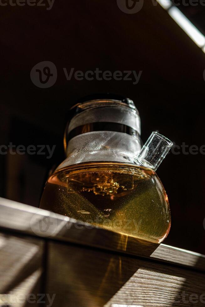 An Elegant Glass Teapot filled with Herbal Tea beautifully displayed in Natural Lighting photo