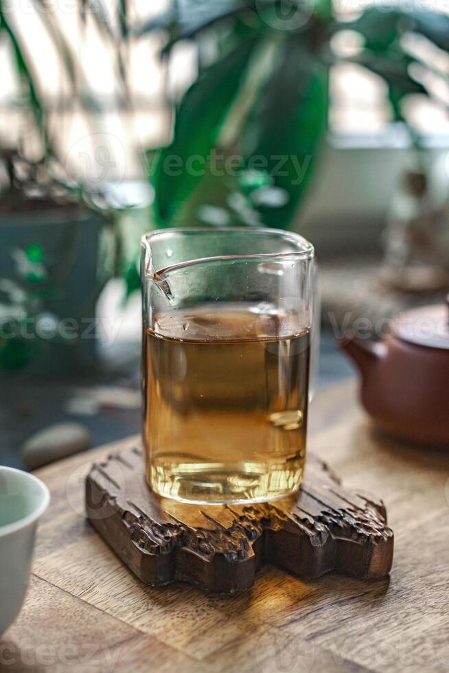 A beautiful Serene Green Tea served in a Glass with a tranquil Nature Background adjacent to it photo