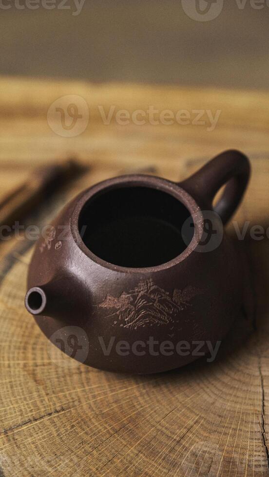 An elegant and traditional clay teapot beautifully positioned on a rustic wooden surface photo