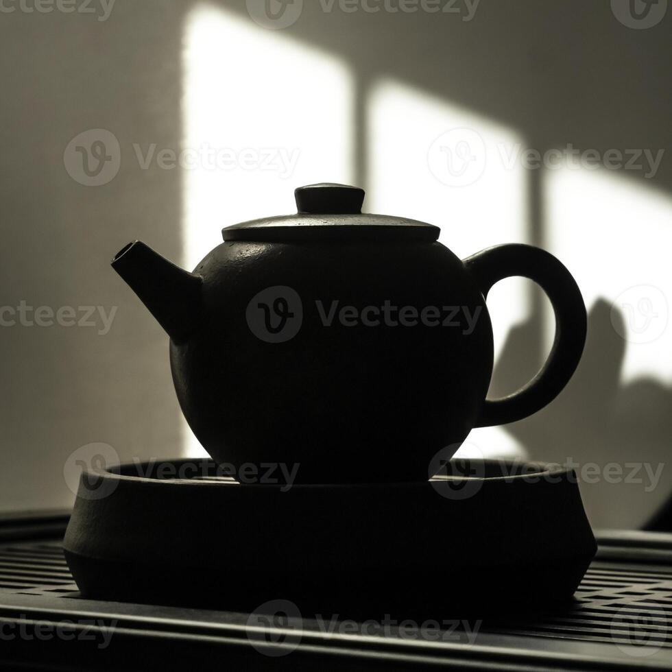 An Artistic and Elegant Silhouette of a Classic Black Teapot Depicting Beautiful Shadows and Light photo