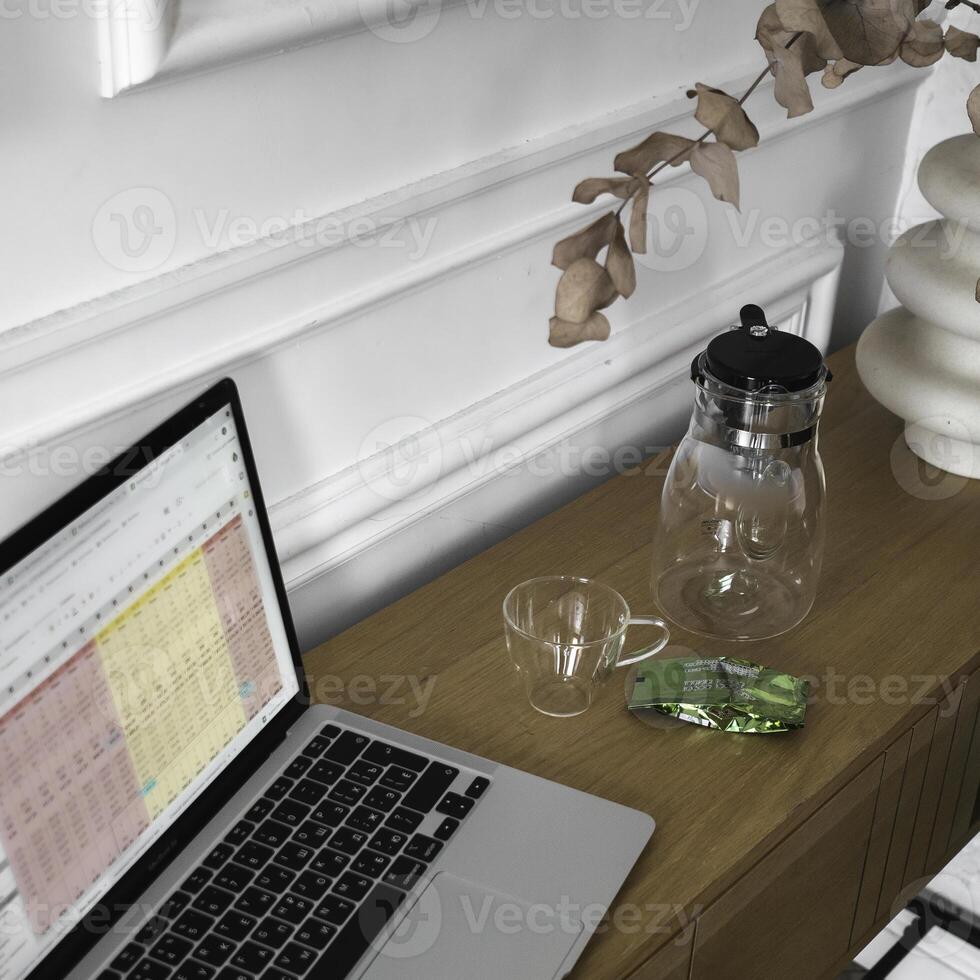 A Stylish Workspace Featuring a Laptop, Beautiful Glassware, and Chic Decor Items to Inspire photo