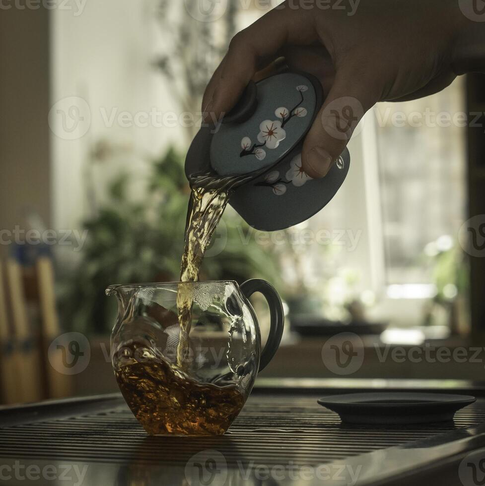 The Art of Tea Pouring a Hot Brew into a Beautiful Glass Cup for Enjoyment and Relaxation photo