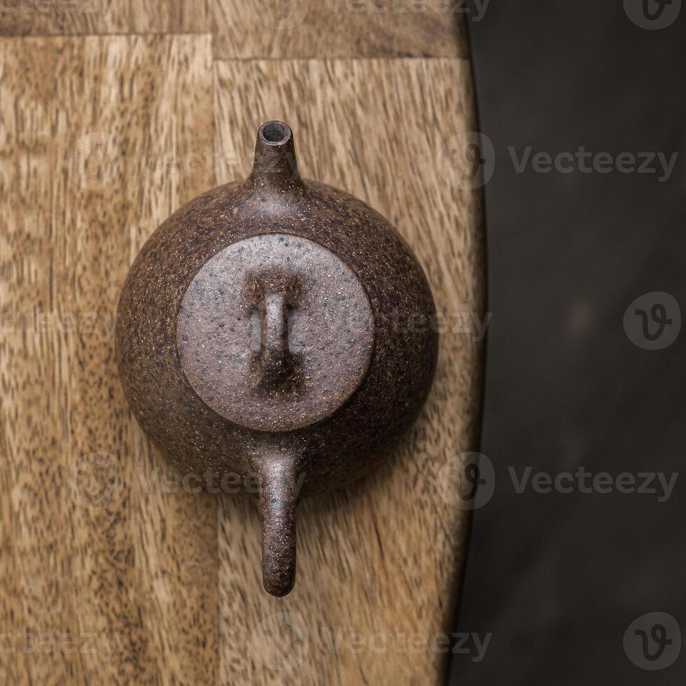 An Elegant Brown Teapot Gracefully Placed on a Beautifully Designed Wooden Table photo