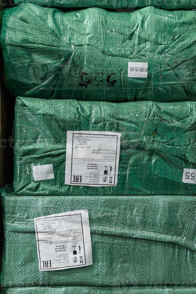 In the warehouse, there are stacked green wrapped packages organized neatly and efficiently photo