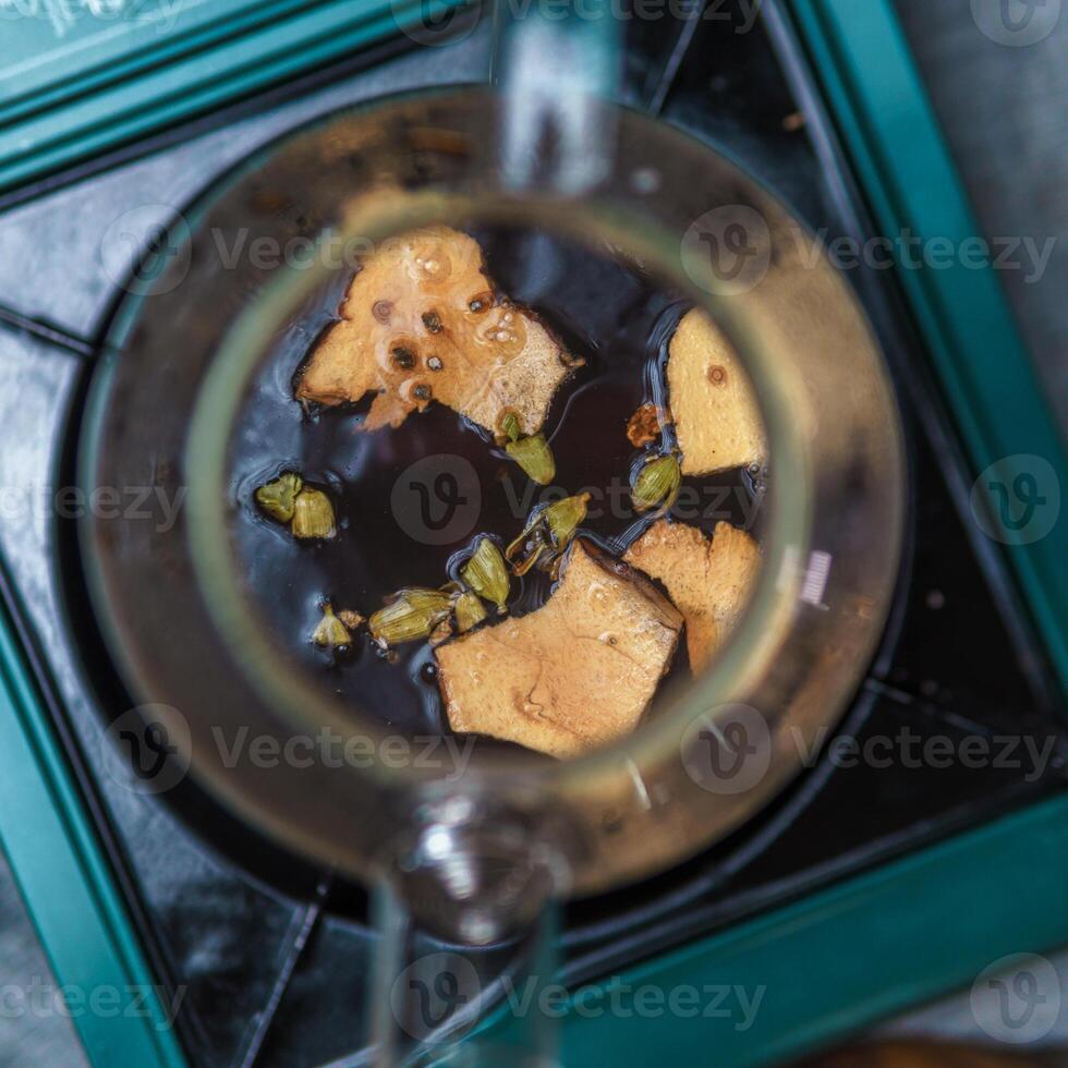Aromatic Spices Infusing Delightfully in a Rich Dark Beverage for Ultimate Enjoyment photo