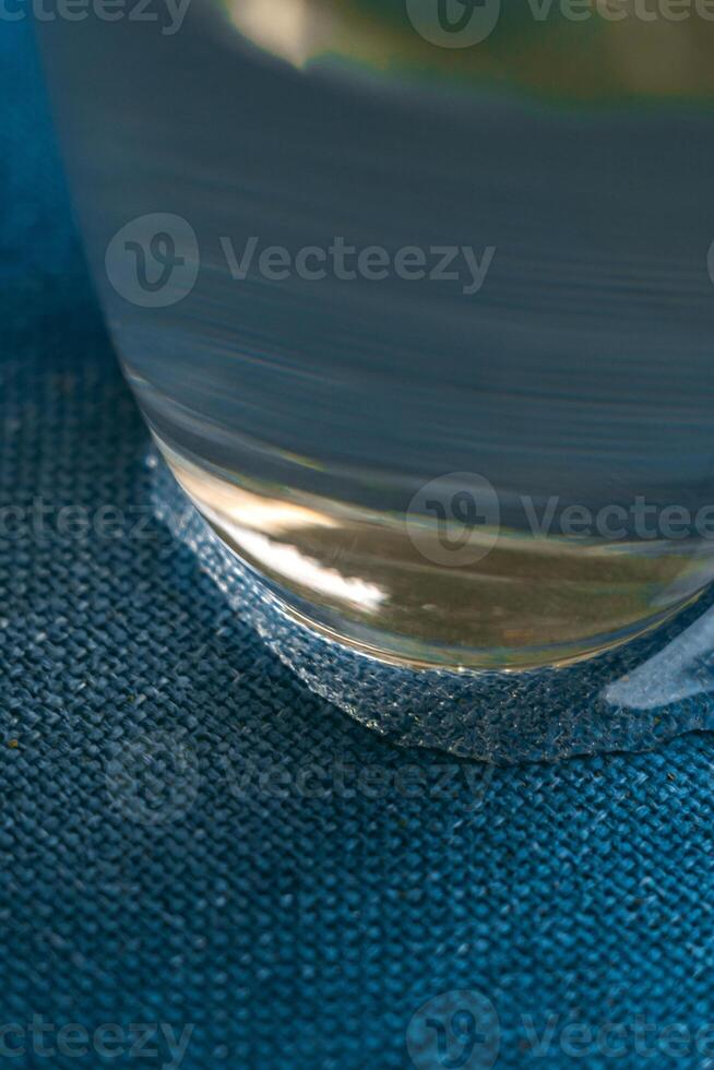A CloseUp Image of a Glass Set Against a Soft Blue Fabric Background with Textures photo