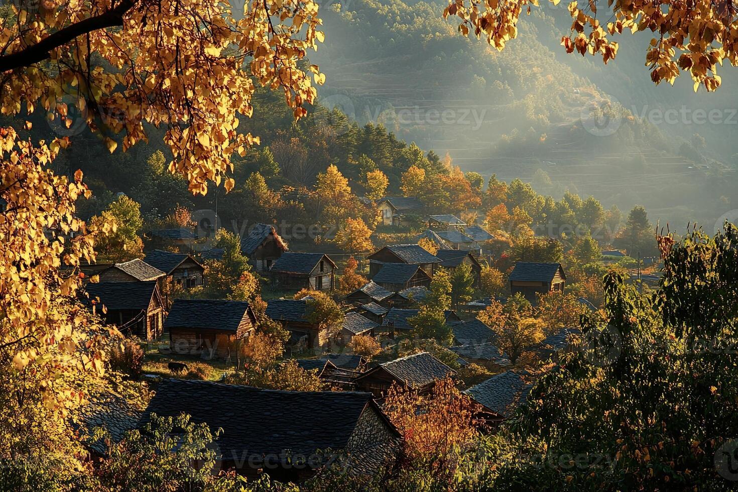 Autumnal village nestled in mountain valley, sunlight through trees. photo