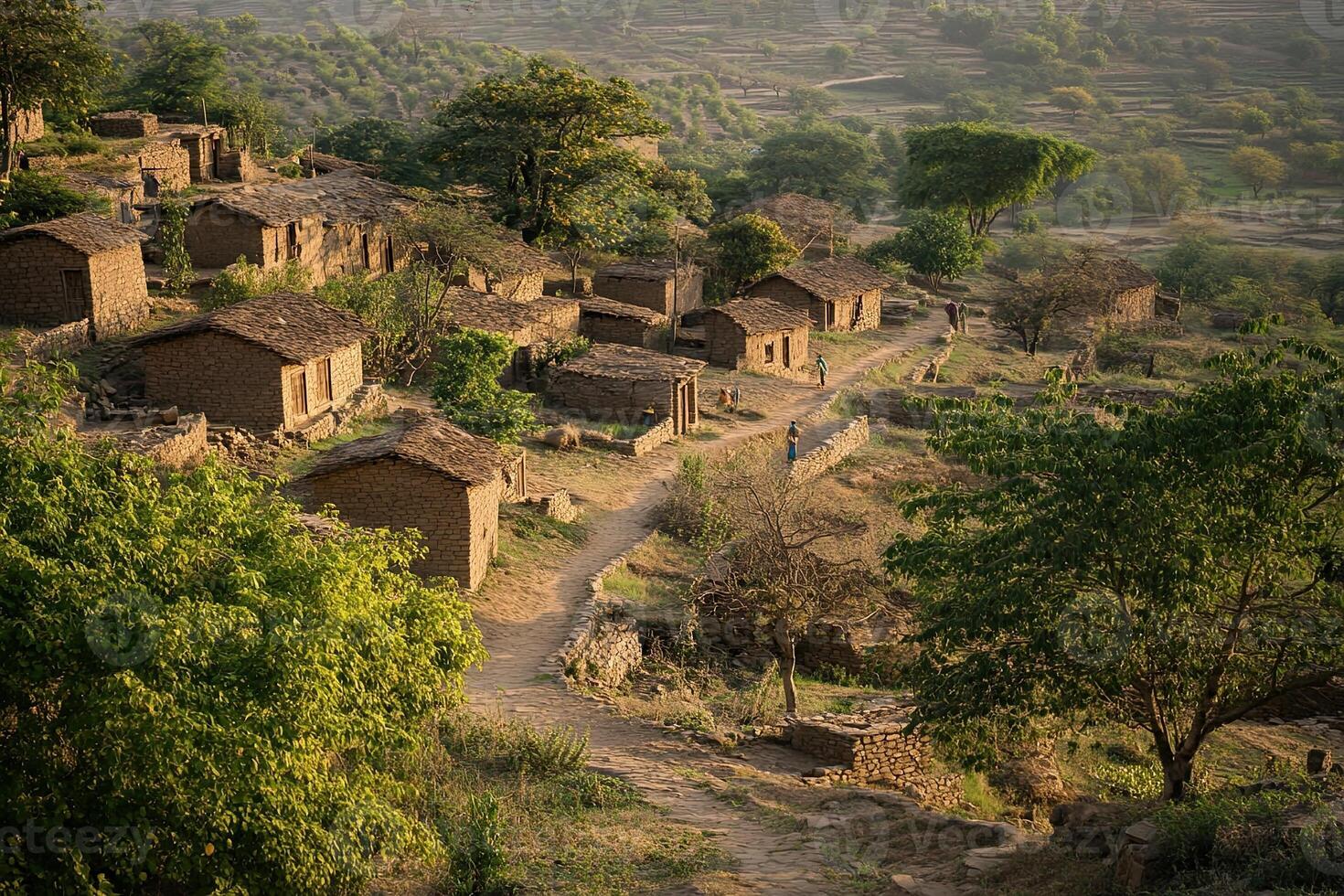 Hillside village with rustic houses, dirt road, and people walking. photo