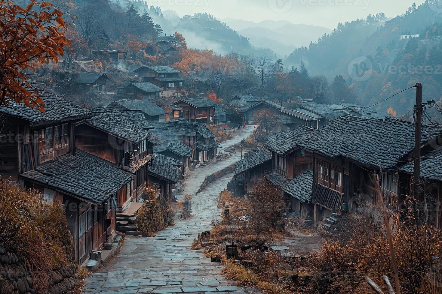Misty mountain village with traditional houses and stone path. photo