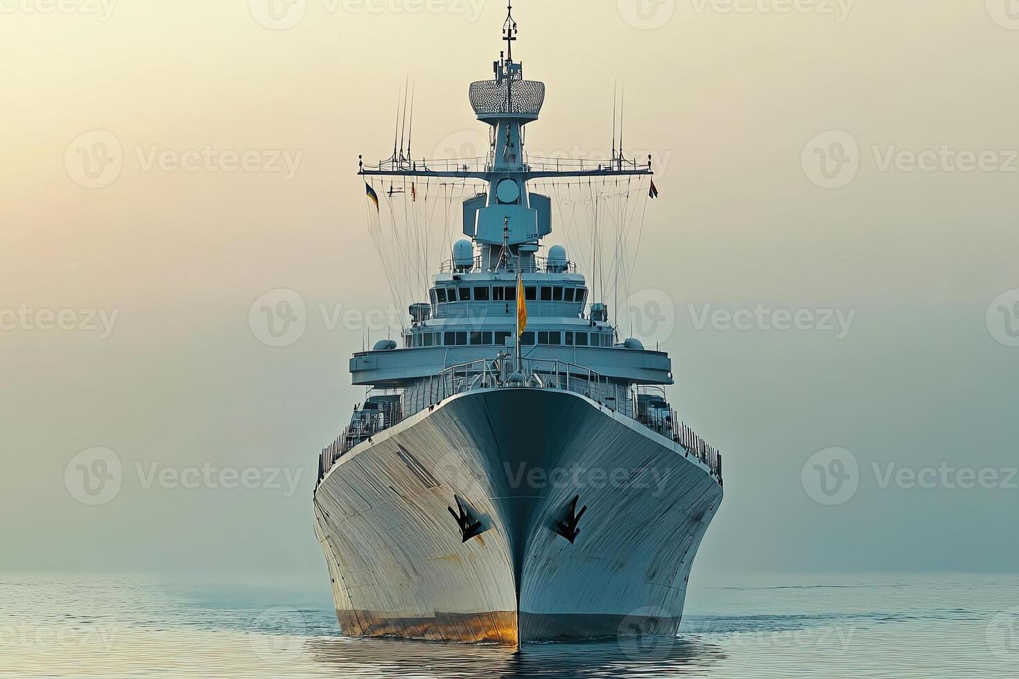 A large naval ship sailing on calm waters at sunrise. photo