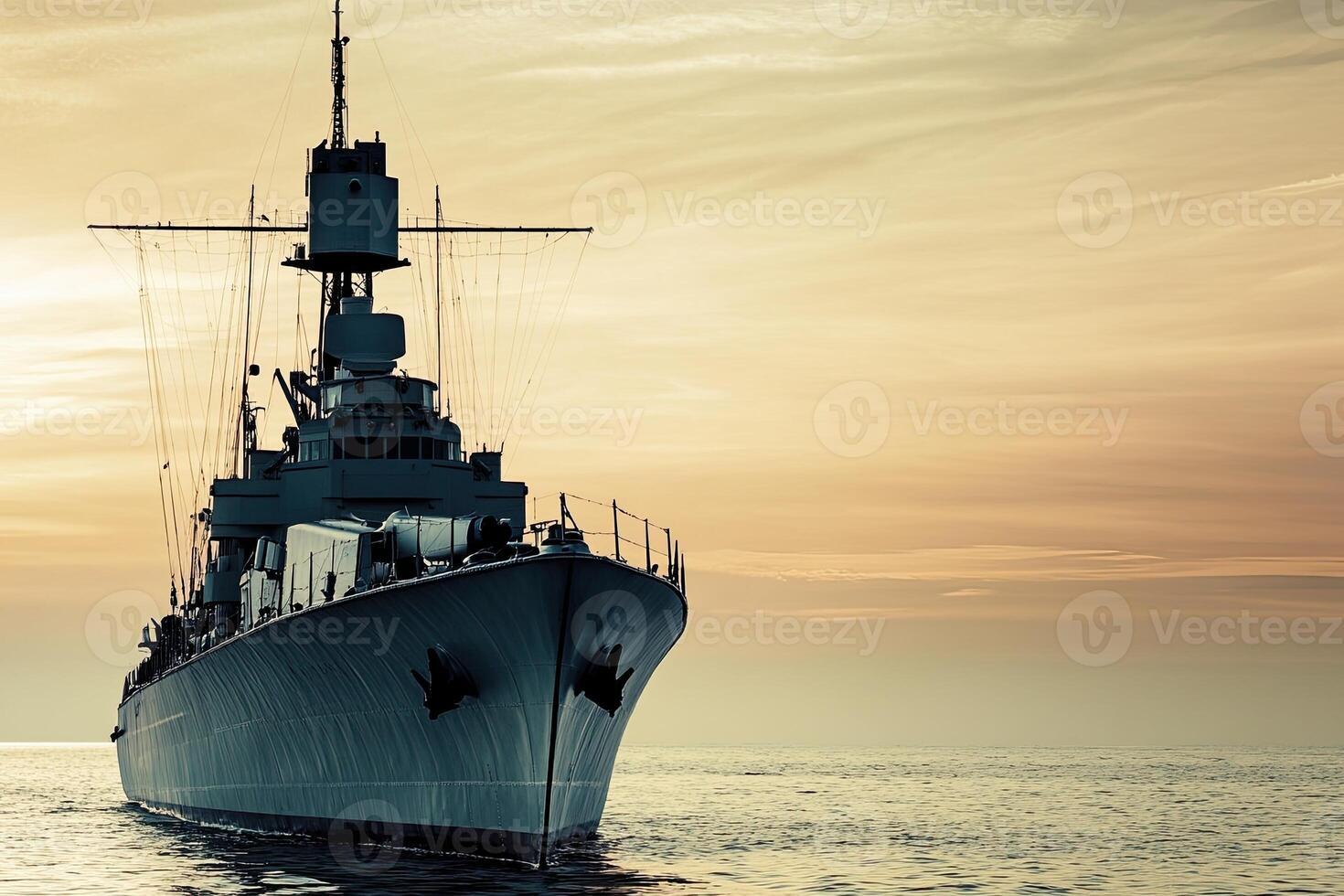 A battleship silhouetted against a sunset at sea. photo