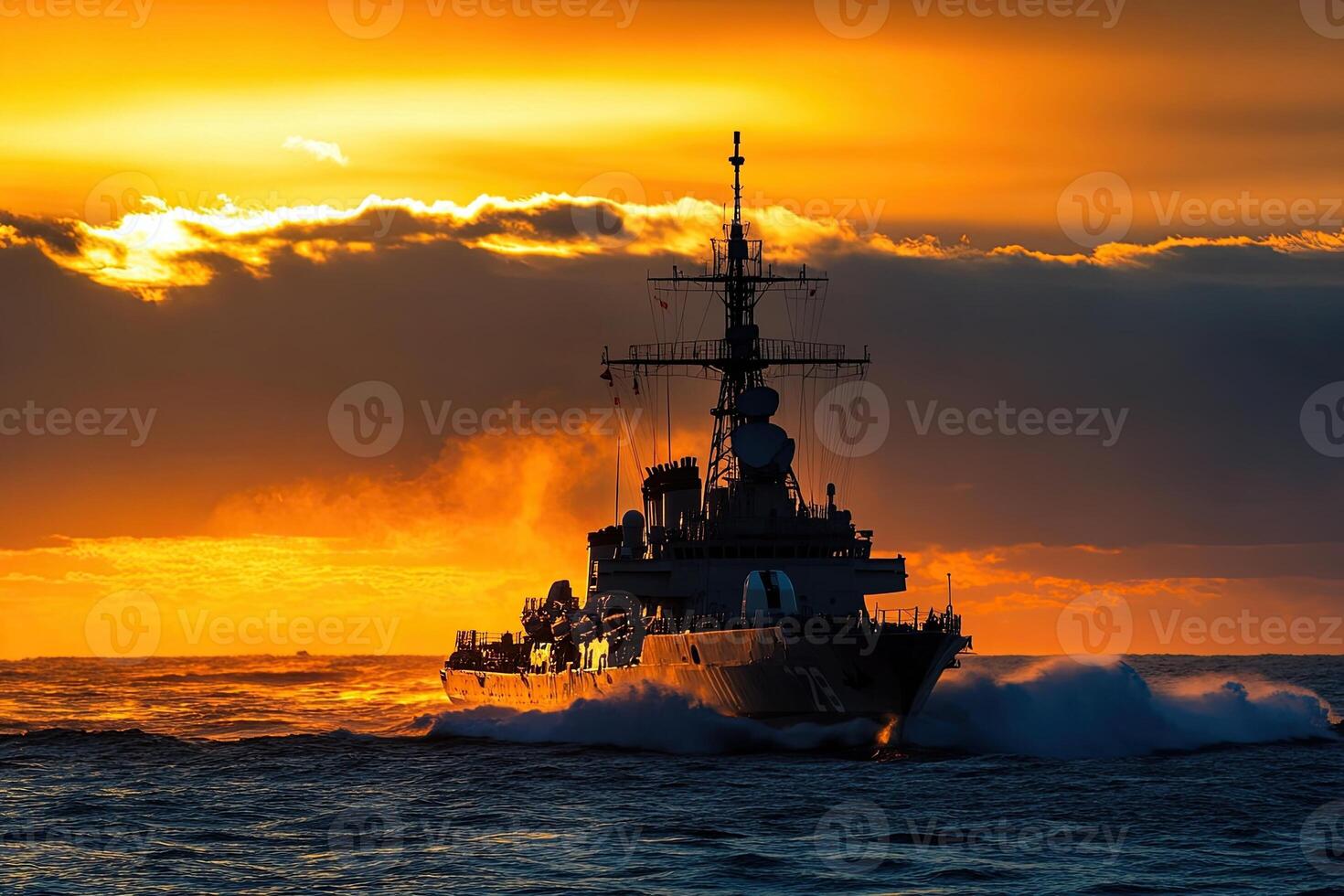 Naval ship navigating through waves at sunset. photo