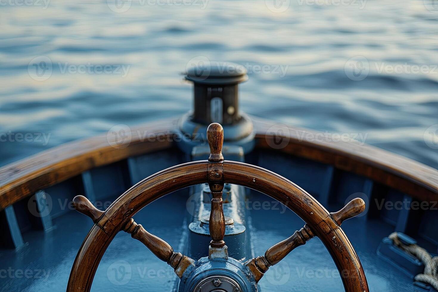 Wooden ship's wheel on a boat with calm water background. photo