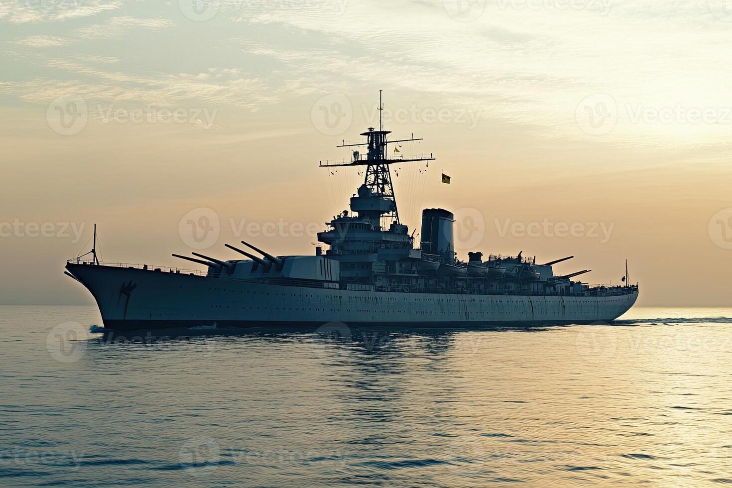 Battleship sailing at sunset on calm waters. photo