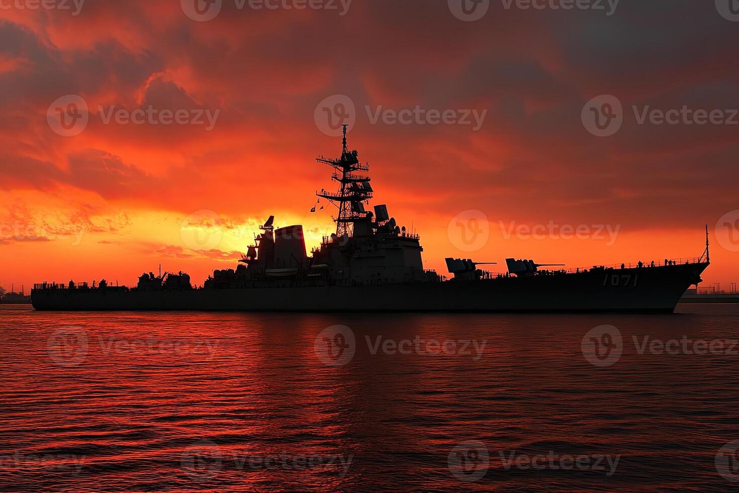 Warship silhouetted against a vibrant sunset. photo