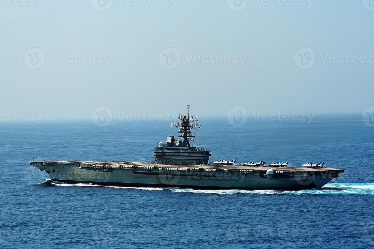 Aircraft carrier navigating through the ocean waters. photo