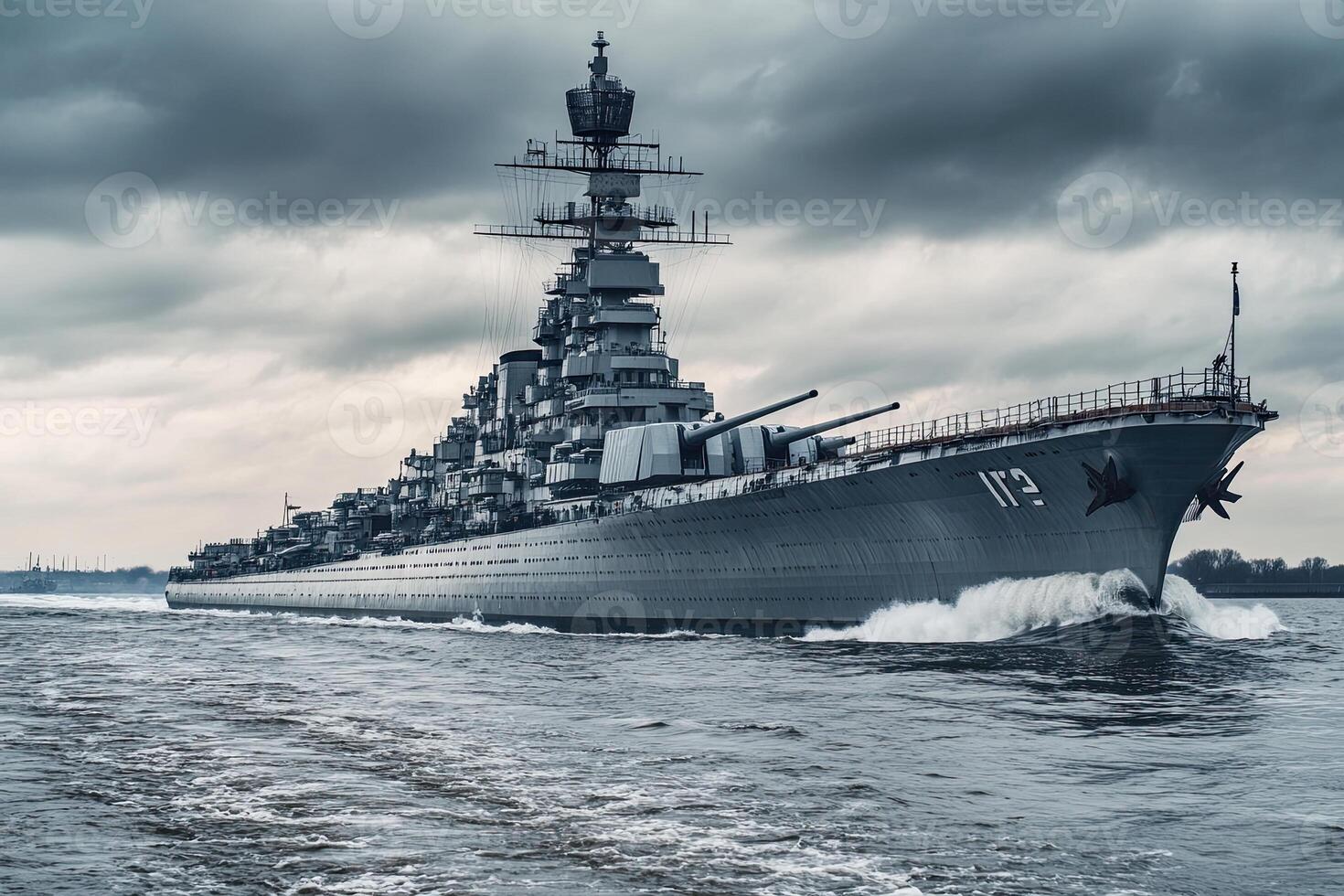 Battleship navigating through rough waters under cloudy skies. photo