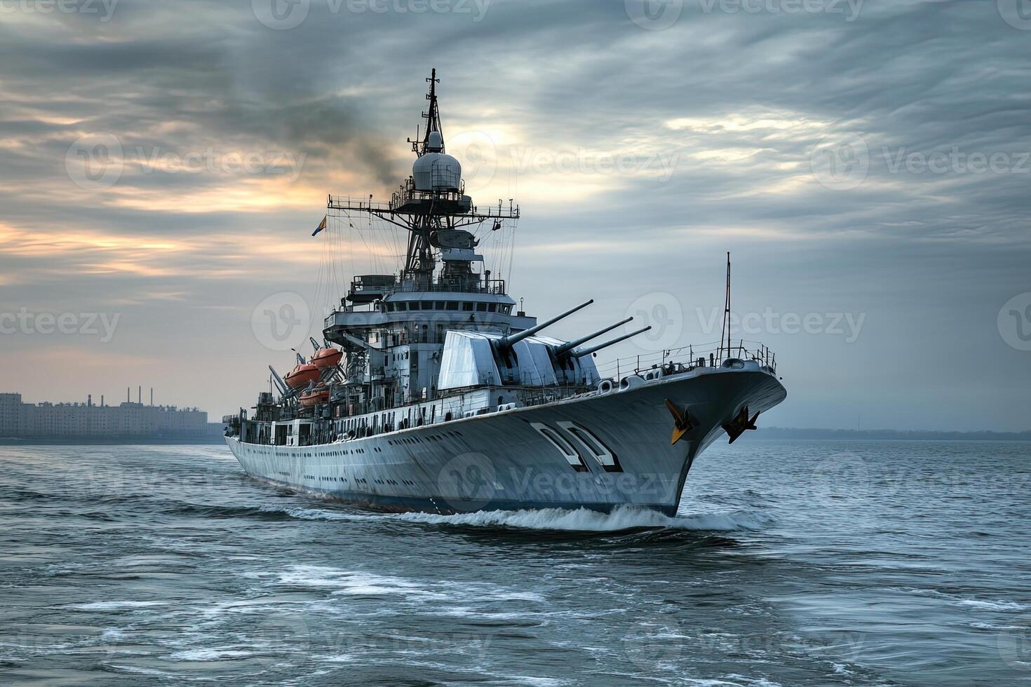 Military ship navigating through water at sunset. photo