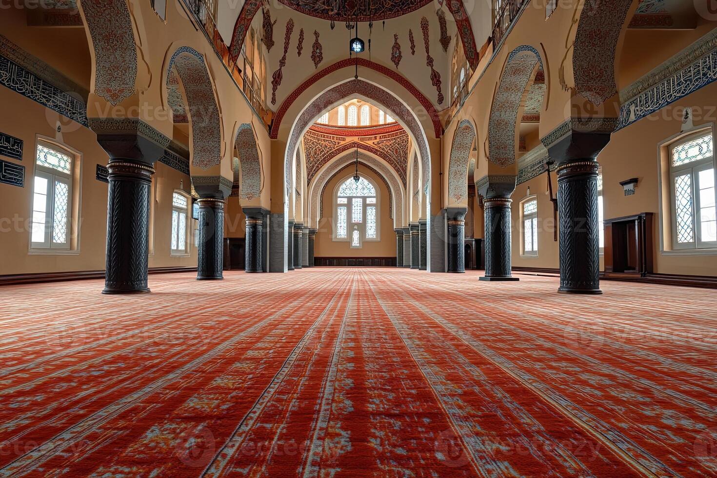 Grand mosque interior with red carpet, arches, and columns. photo