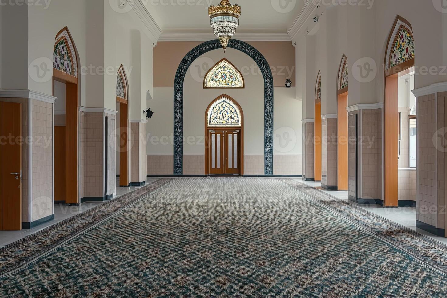 Empty mosque hallway with arched doorways, stained glass windows, and patterned carpet. photo