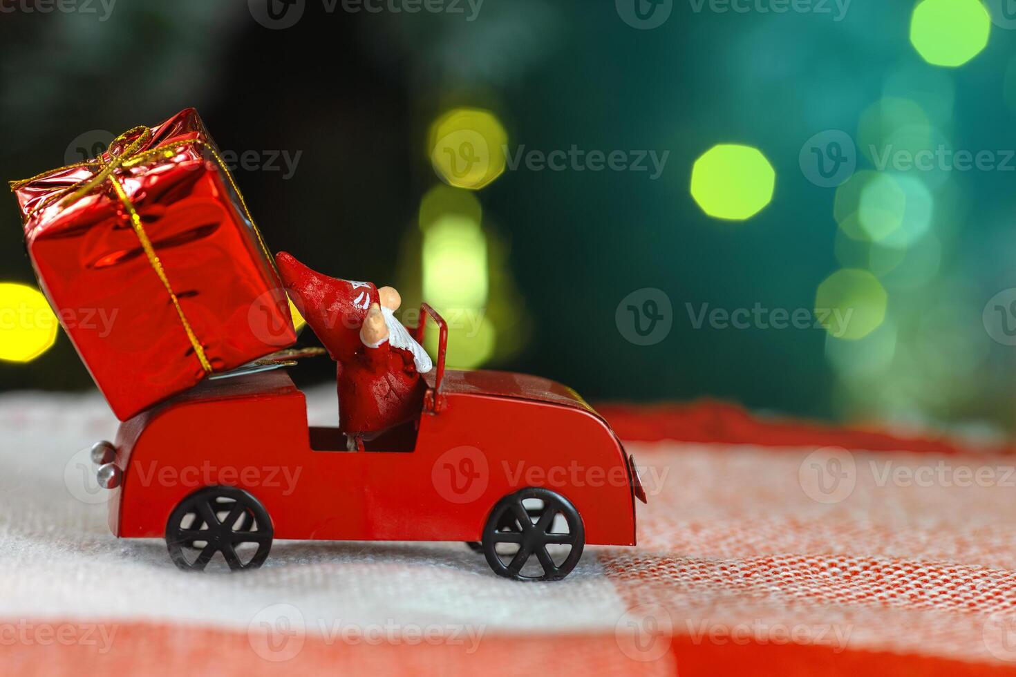 Festive holiday scene with toy car and santa figurine delivering a christmas gift photo
