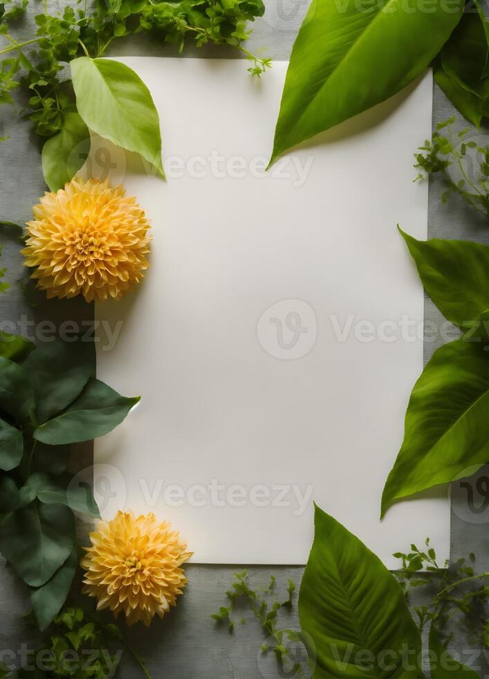 blank paper with green leaves and flowers on a gray background photo