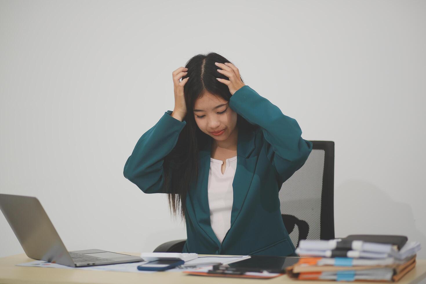 Stressed female worker and business woman holding a pile of paperwork while getting more work to do. Looking frustrated in camera, isolated on white background. Concept Too much work photo