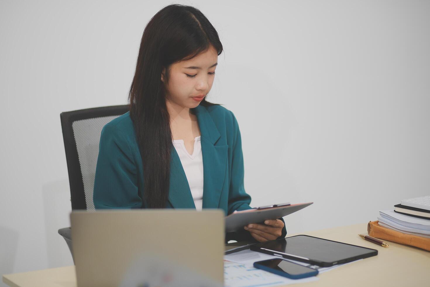 Asian business woman working using laptop computer, marketing report with calculator document on table Planning to analyze financial reports Investing in an online business plan, e-commerce. photo