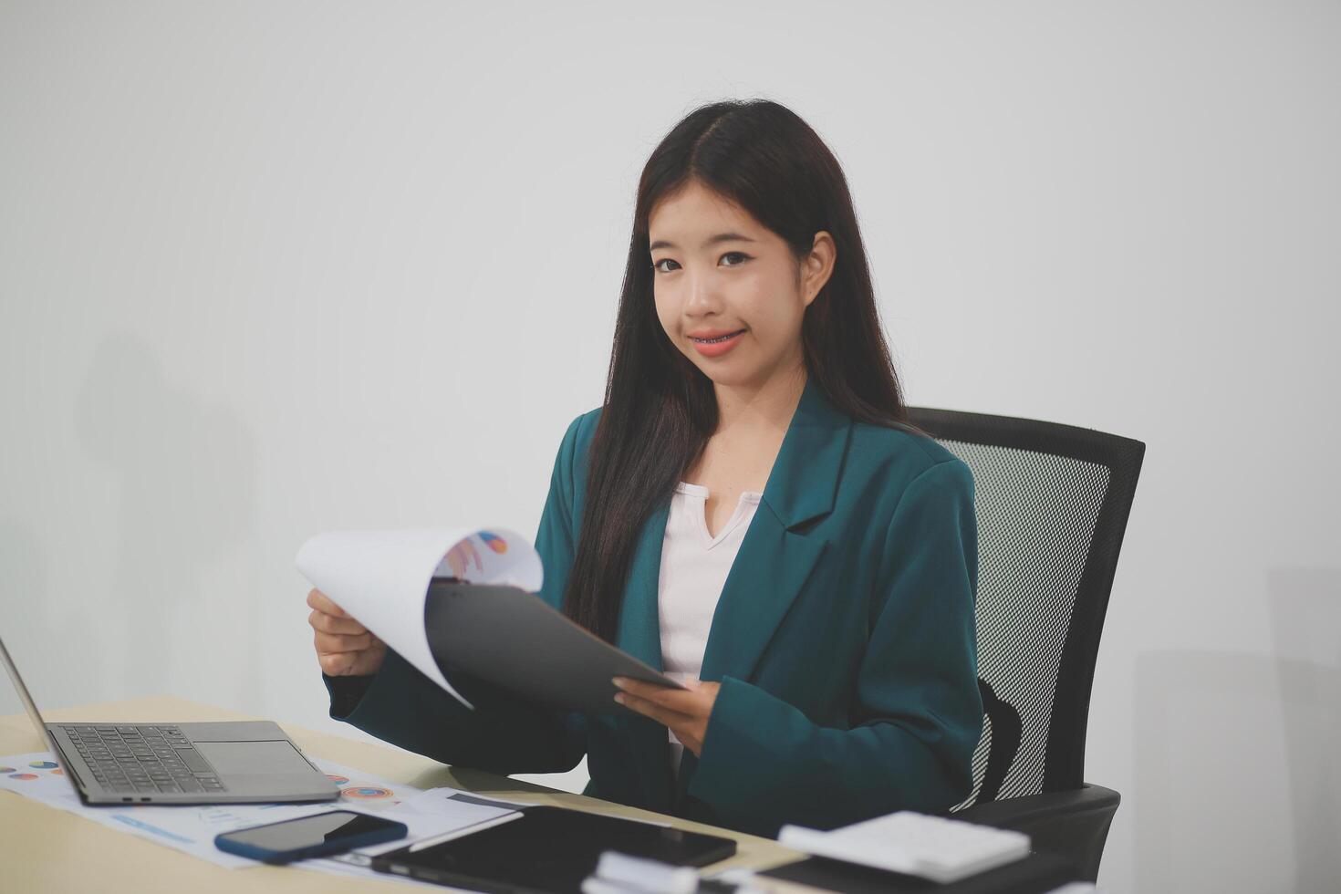 Asian business woman working using laptop computer, marketing report with calculator document on table Planning to analyze financial reports Investing in an online business plan, e-commerce. photo