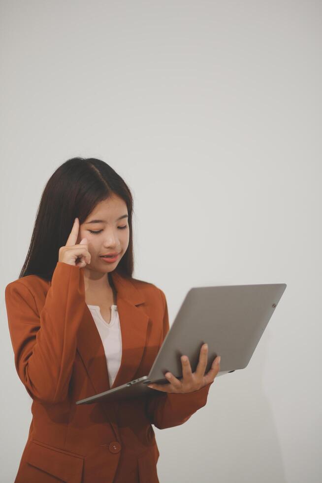 Young beautiful Asian woman in business office standing use tablet in hand, Thai girl enjoy browsing for online shopping store with copy space for advertisement, on isolated white background photo