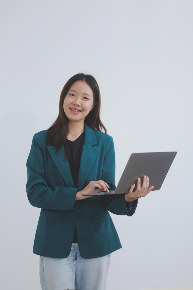 Attractive elegant young asian business woman using digital tablet standing on isolated background. Happy young latin female formal black suit holding tablet gadget working service with customer photo