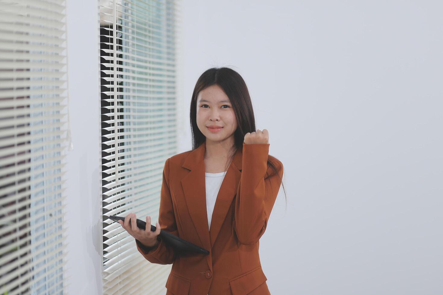 Happy relaxed young woman standing in home office using tablet, excited lady laughing holding tablet, enjoying doing online ecommerce shopping in mobile apps photo