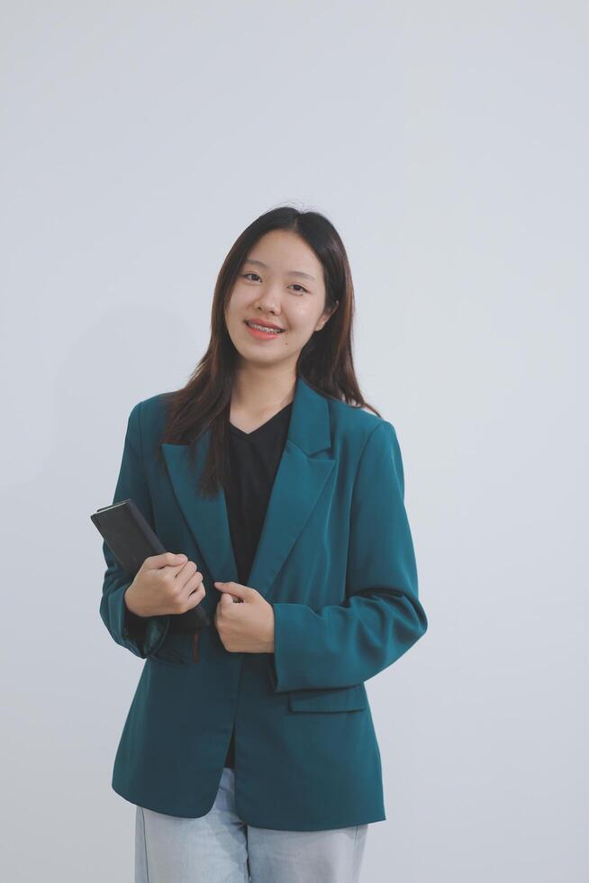 Attractive elegant young asian business woman using digital tablet standing on isolated background. Happy young latin female formal black suit holding tablet gadget working service with customer photo