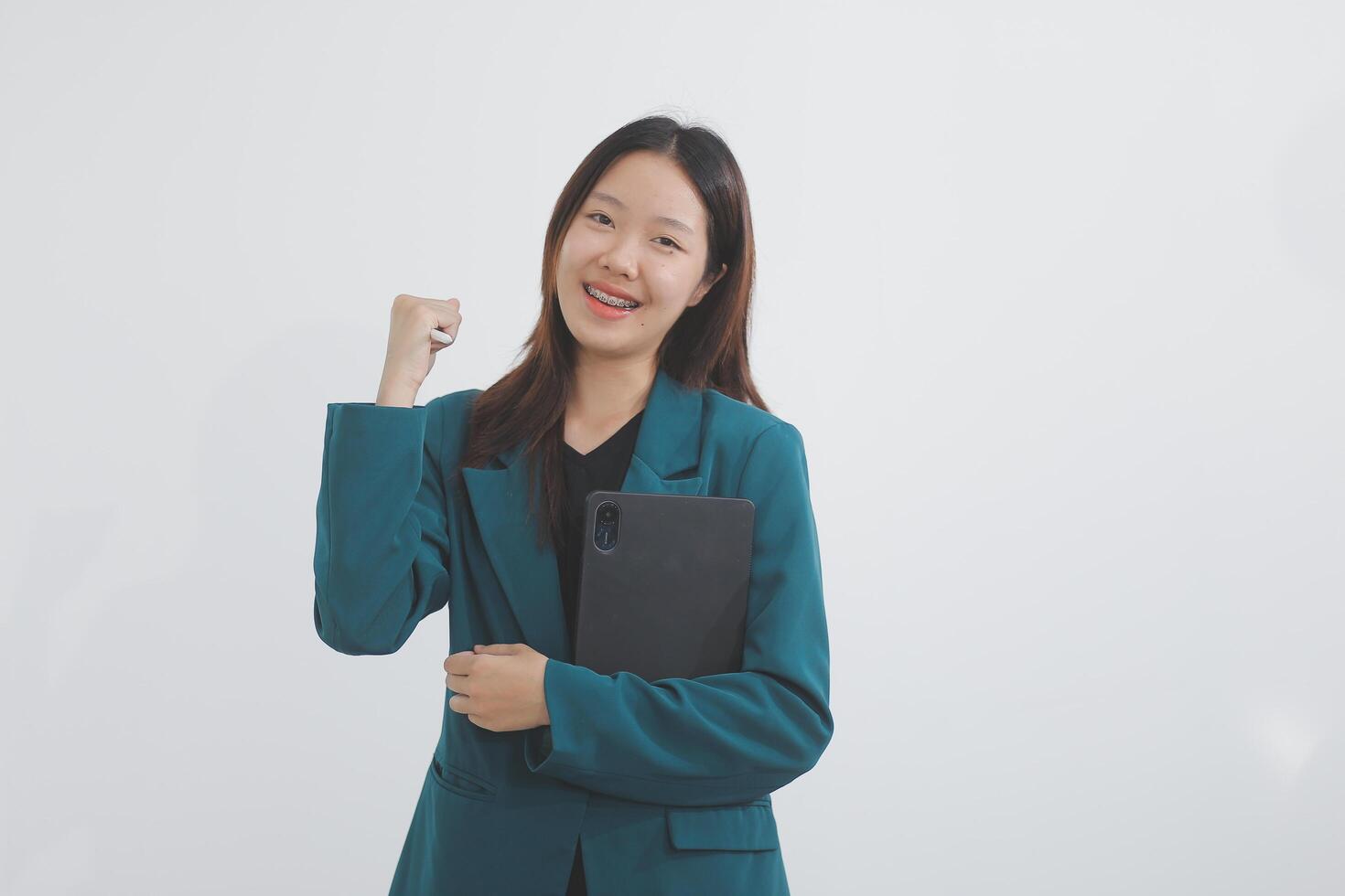 Attractive elegant young asian business woman using digital tablet standing on isolated background. Happy young latin female formal black suit holding tablet gadget working service with customer photo