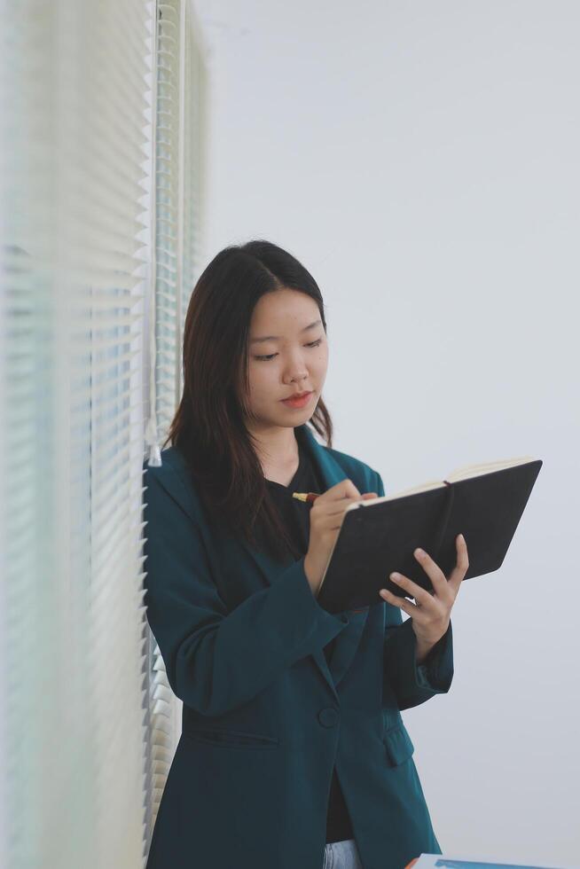 business woman working with laptop while consulting some invoice and document in working space at home photo