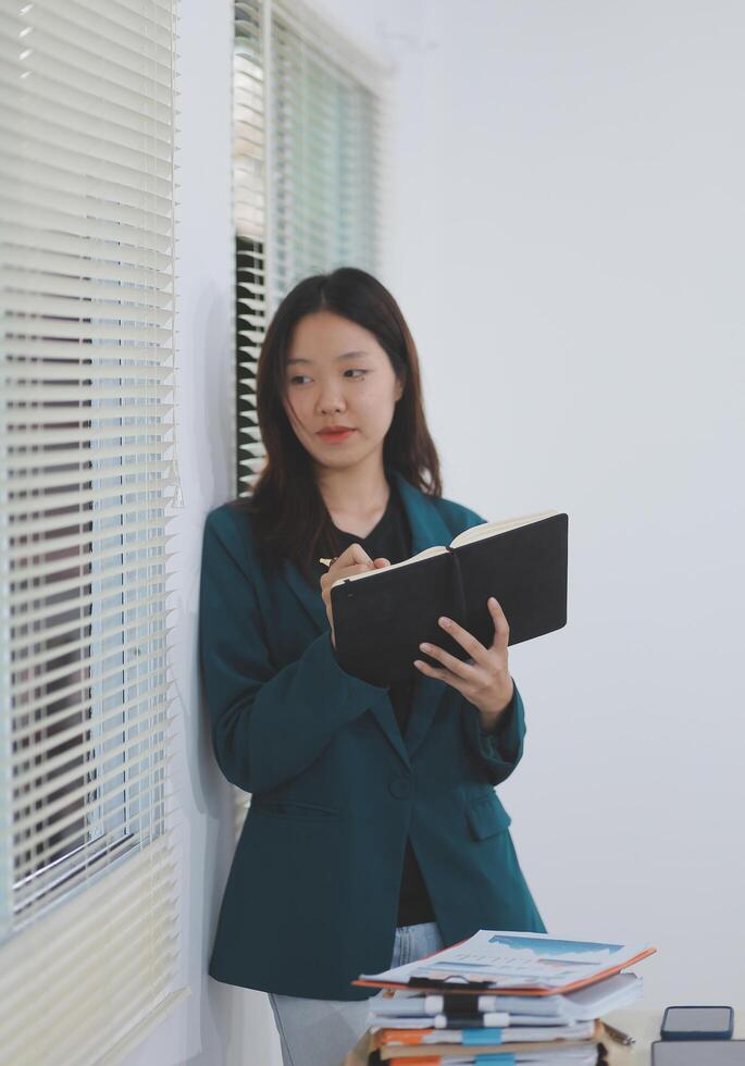 business woman working with laptop while consulting some invoice and document in working space at home photo