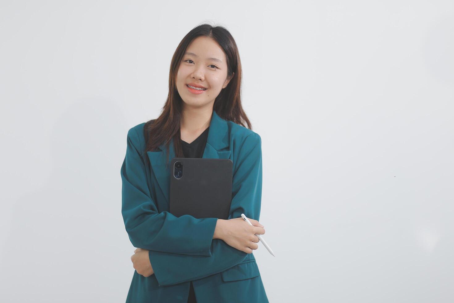 Attractive elegant young asian business woman using digital tablet standing on isolated background. Happy young latin female formal black suit holding tablet gadget working service with customer photo
