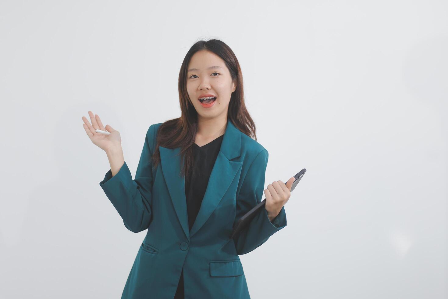 Attractive elegant young asian business woman using digital tablet standing on isolated background. Happy young latin female formal black suit holding tablet gadget working service with customer photo