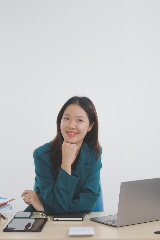 A young woman sitting at a table using a laptop stationary equipment headphones to work online or do homework for study is the life style of a teenager. photo