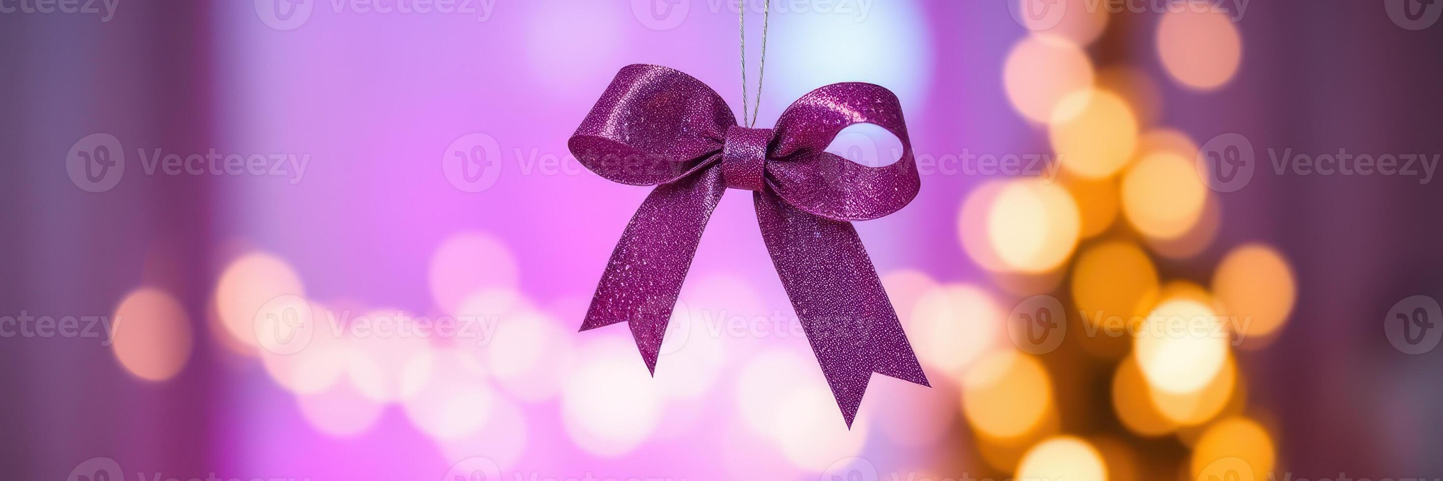 Decorative purple bow hanging with soft bokeh lights for festive celebration in indoor setting photo