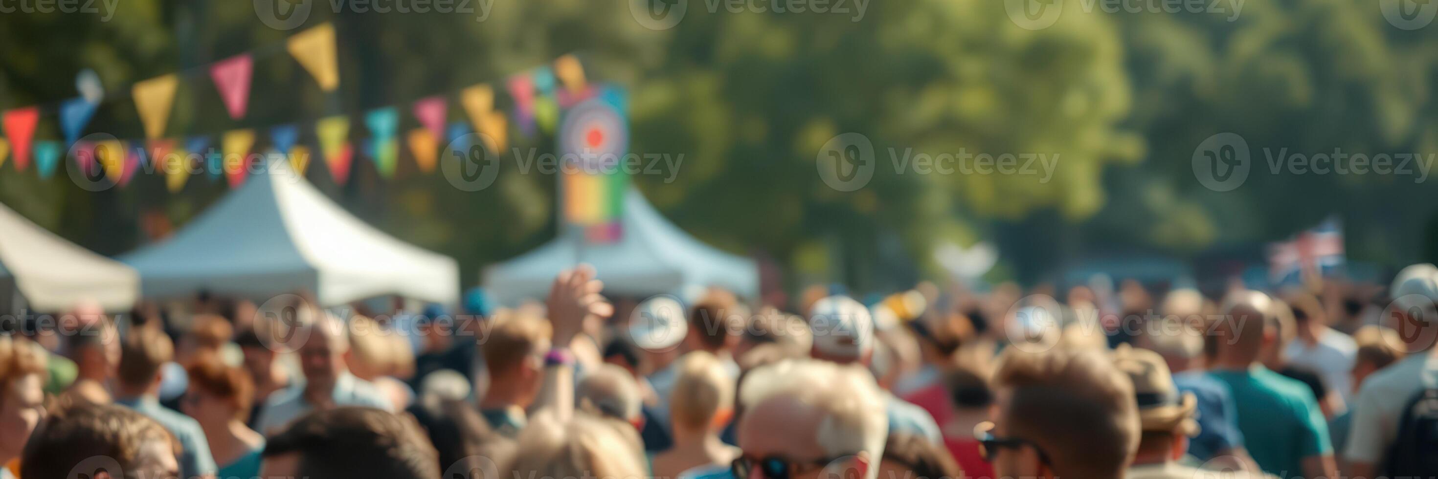 Crowd gathering at a vibrant outdoor festival with colorful decorations and tents in a sunny park photo