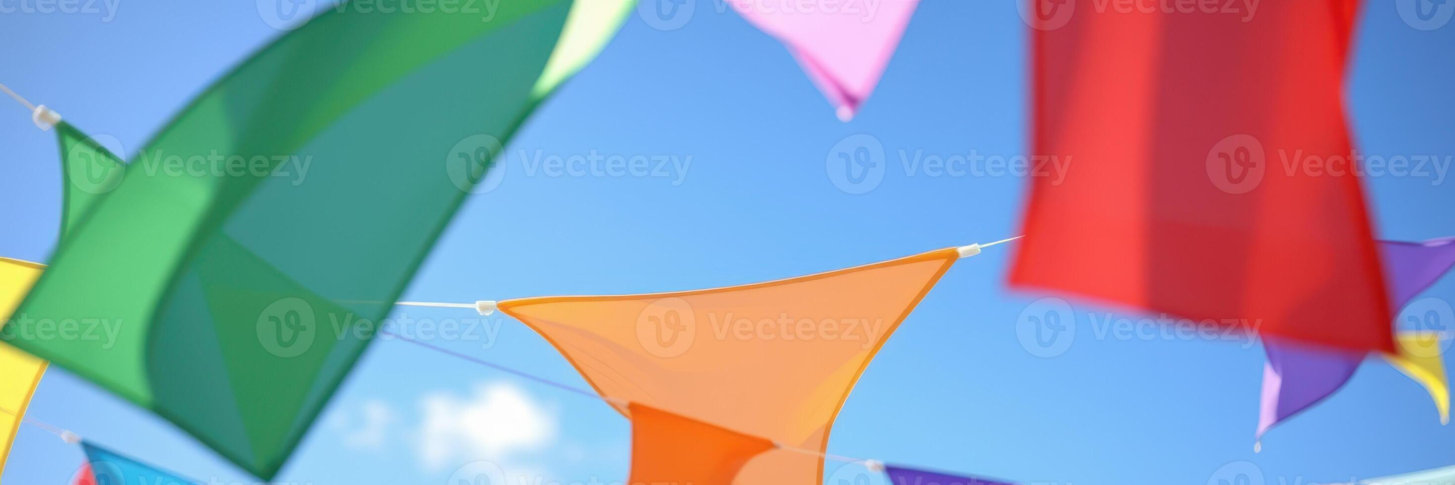 Colorful fabric flags sway gently under a clear blue sky during a festive celebration in a vibrant outdoor setting photo