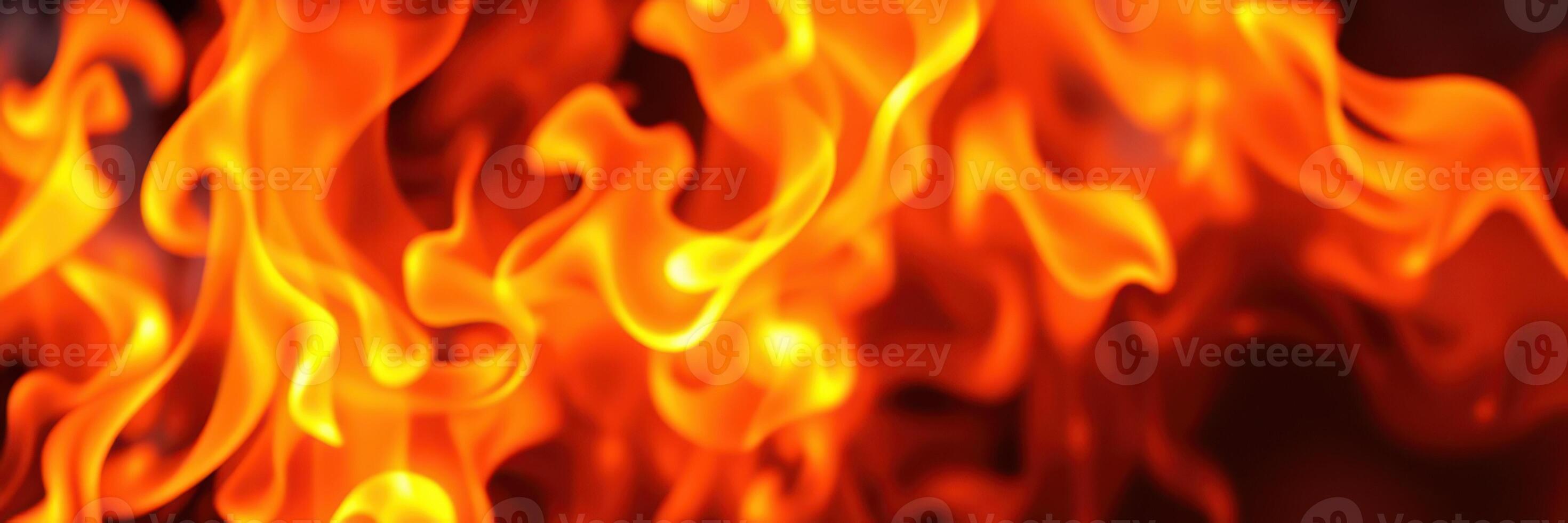 Vibrant flames dance in a mesmerizing display of fire and heat, captivating the viewer's attention in a dark setting photo