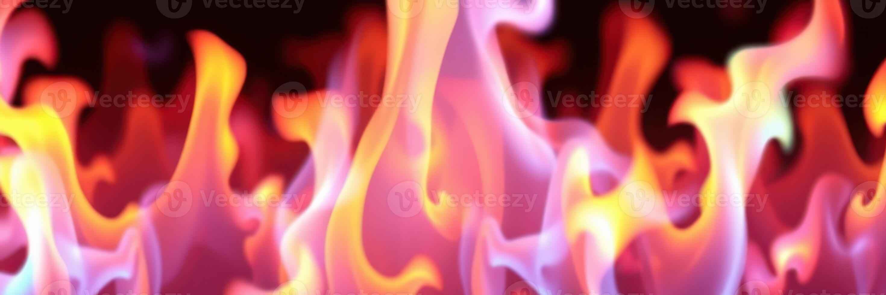 Dancing flames create a mesmerizing display of orange and purple hues in a darkened setting during a festive gathering photo