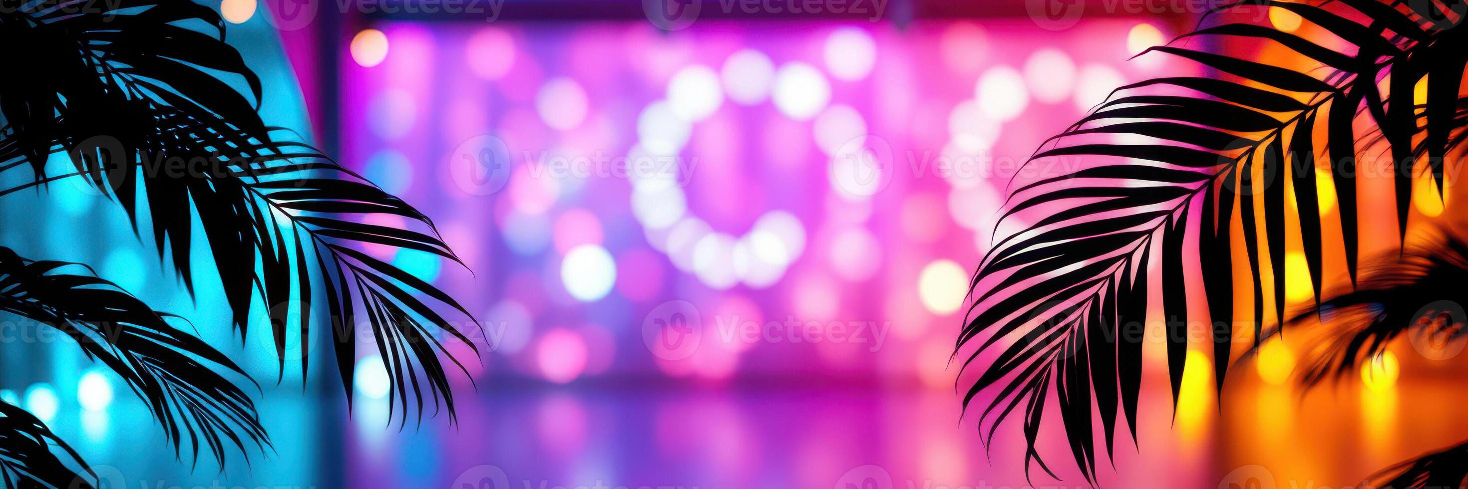 Colorful lights illuminated in a festive setting with palm leaves framing the vibrant background at an evening event photo