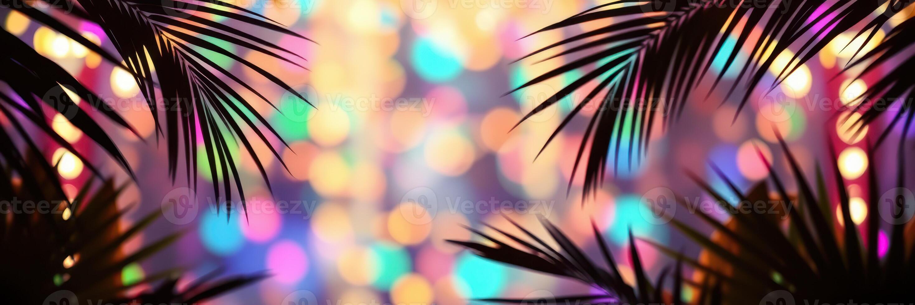 Colorful lights shine through palm leaves during a festive evening gathering in a tropical location photo