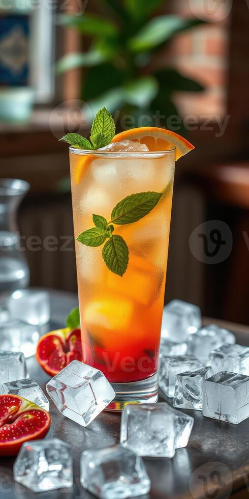 Refreshing cocktail garnished with mint leaves and orange slice served over ice in a bright bar setting photo