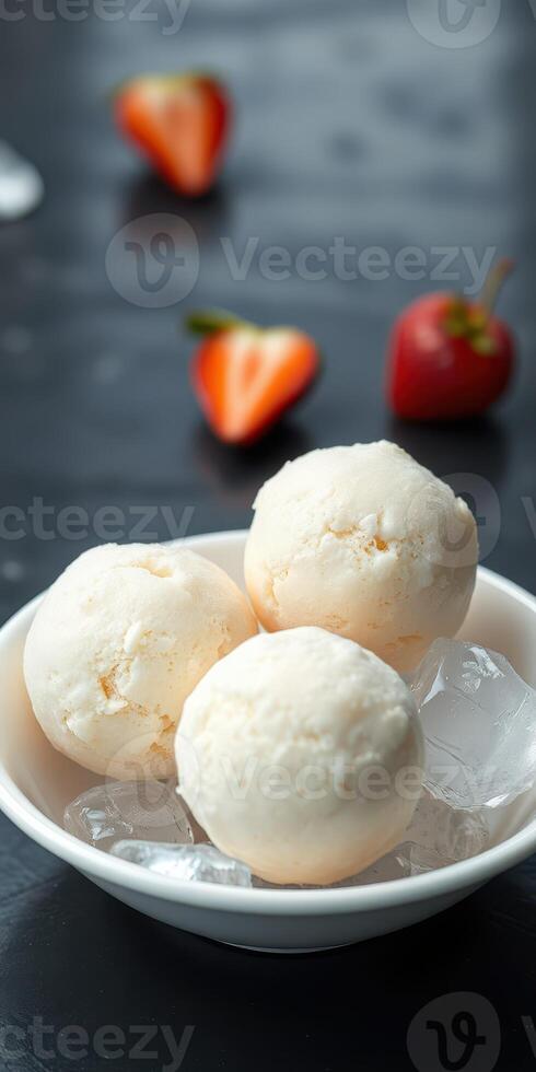 Delicious scoops of ice cream served in a bowl with fresh strawberries on a dark table photo